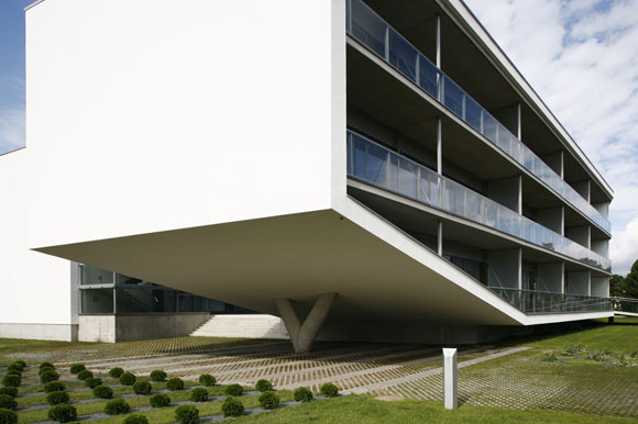 The 47 APARTMENTS are primarily for seasonal use. The galleries leading up to the apartments are interior streets with outside temperature. The whole building stands elevated by half a storey in order to accommodate a car park below the building and protect the apartments from possible floods in the town. A wide concrete ramp leading up to the entrance hall can be used as a boat landing at times of flooding.